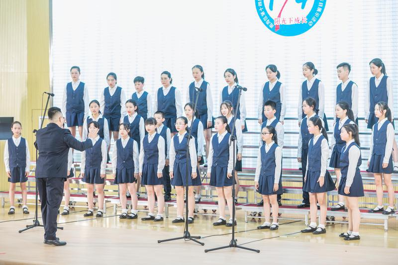 南海外国语学校在台上进行《奉献》和《The water dance of lluvia》合唱展演。/佛山日报记者王伟楠摄