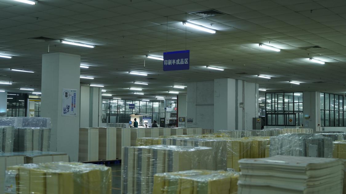 华新彩印生产车间堆满了印刷产品。.JPG