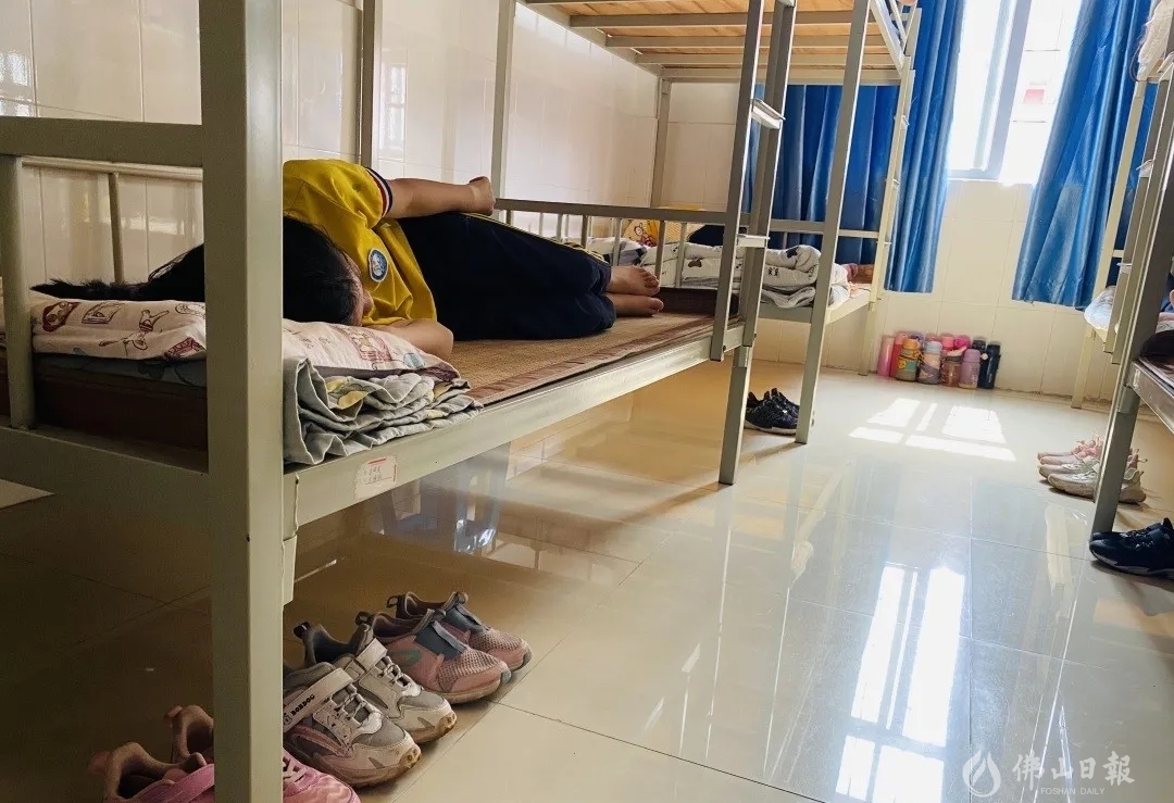 午休时间到,高明一中实验学校的老师们移动课桌椅,铺平折叠床,将原本