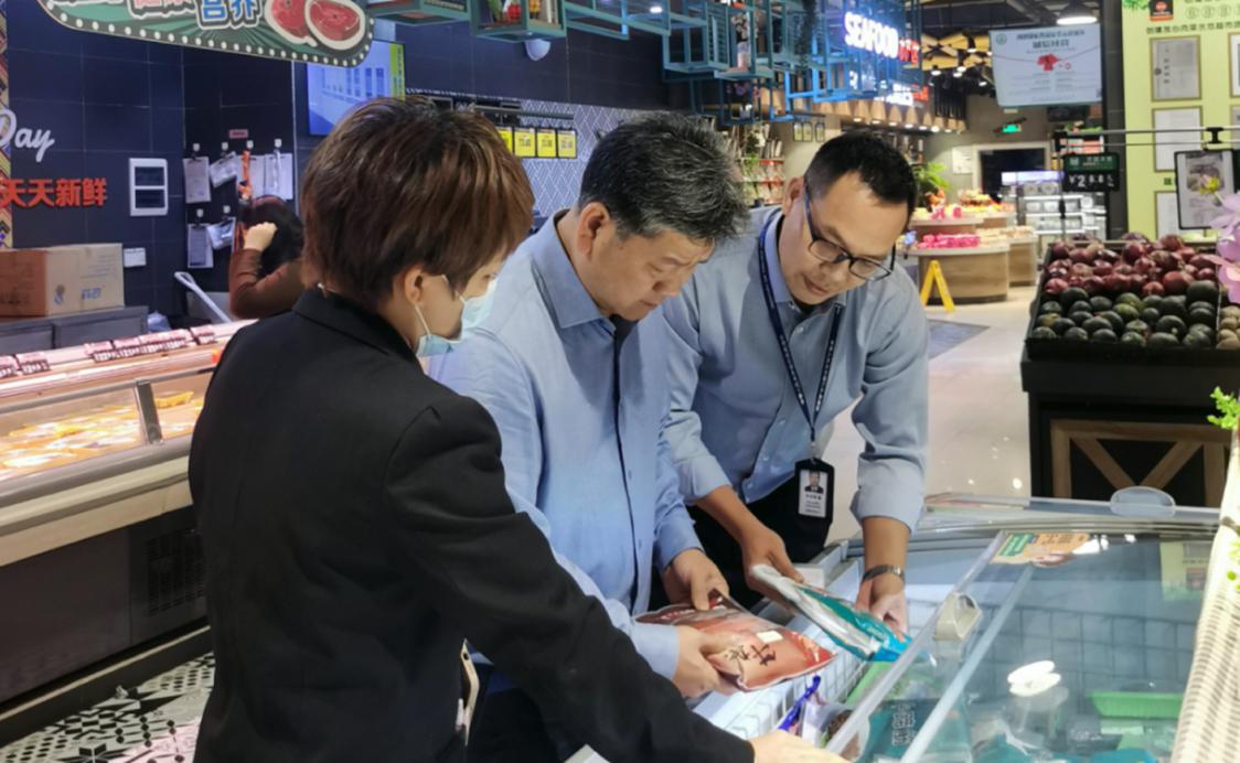 在日日升超市,谭桂清(中)一行检查了食品和肉制品进货凭证、食品抽检及过期食品管理办法等台账资料。部门供图.png