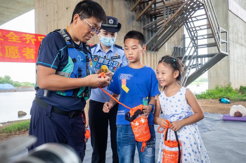 2021年7月22日,青少年“防溺水”志愿服务队成立后正式上岗,小朋友现场体验使用救生抛绳包。/佛山日报记者符诗贺 实习生黄余雄摄