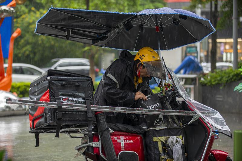 佛山风雨逐渐加大，外卖配送员穿着雨衣配送。佛山日报记者符诗贺摄