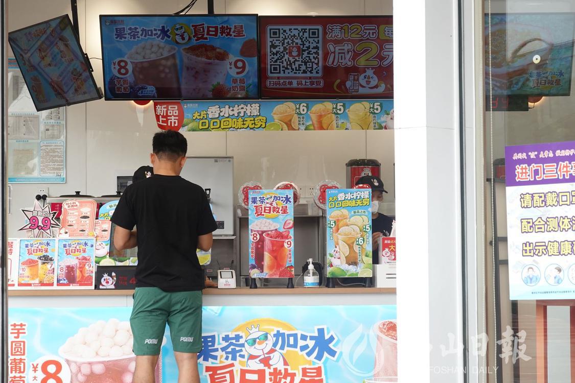 在高明荷城街道沧江路,一市民正在奶茶店内购买奶茶。佛山日报记者陈嘉懿摄.jpg