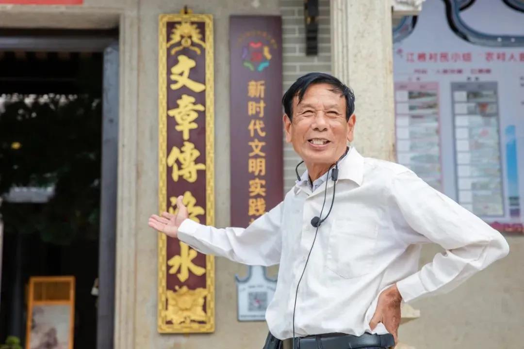 照片3.西南街道江根村村民陆阜年作为江根村的义务讲解员正在向游客介绍村里的嵗松陆公祠.jpg