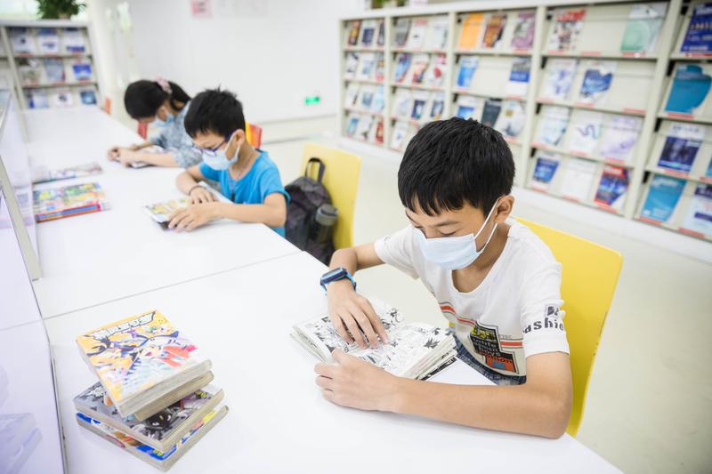 孩子们选择在图书馆过暑假，看书充实假期。/佛山日报记者王伟楠摄