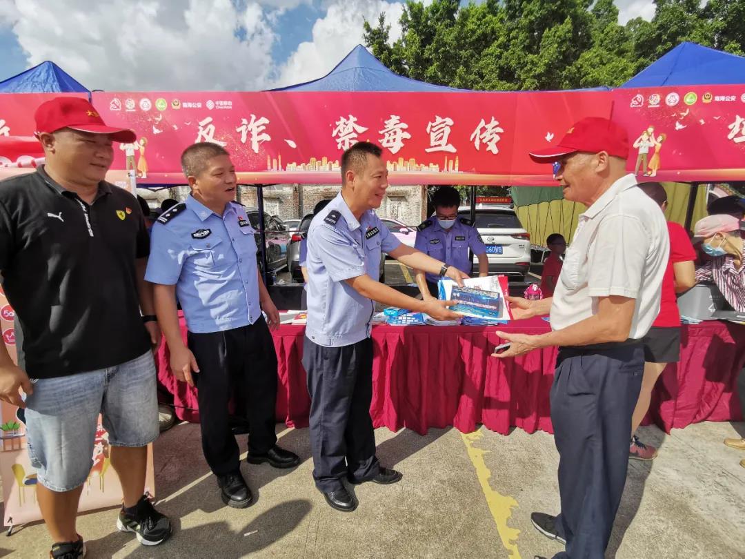 民警向现场村民派发宣传单张和小礼品。