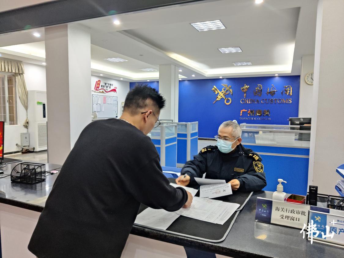 在佛山海关驻三水办事处,企业人员正在海关行政受理窗口办理相关文件。.jpg