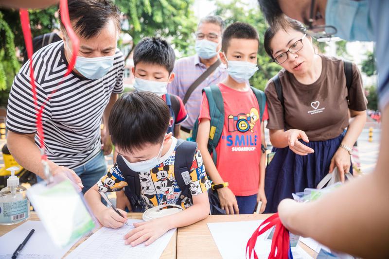2021年7月26日，禅城区绿景小学，家长们带着孩子前来参加暑期托管，现场登记相关信息。/佛山日报记者王伟楠摄
