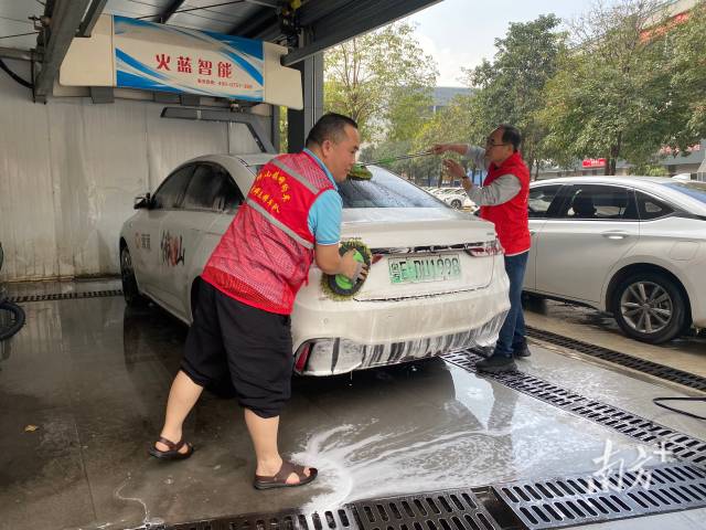 狮山镇流动党员参与志愿洗车活动。