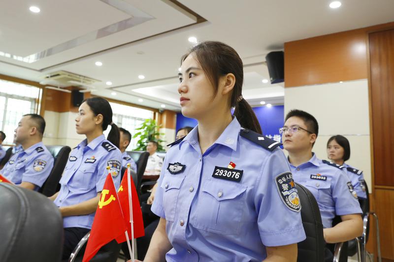 佛山边检站民警手持党旗收看庆祝中国共产党成立100周年大会直播。/佛山日报摄影俱乐部 刘宇巍摄