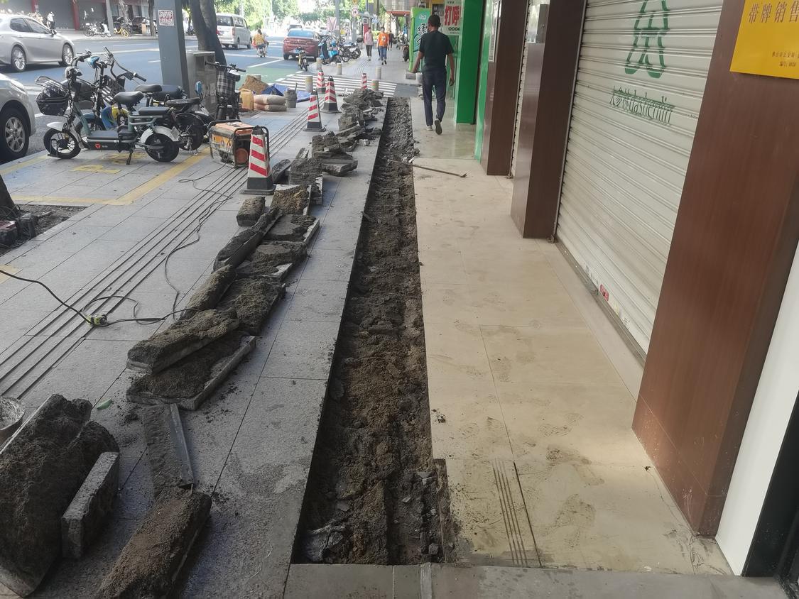 把店铺和路基交界处的人行道砖抬高,形成一个反向横坡,将地势最低点引到人行道上去,积水就不会流到店铺里。受访者供图.jpg