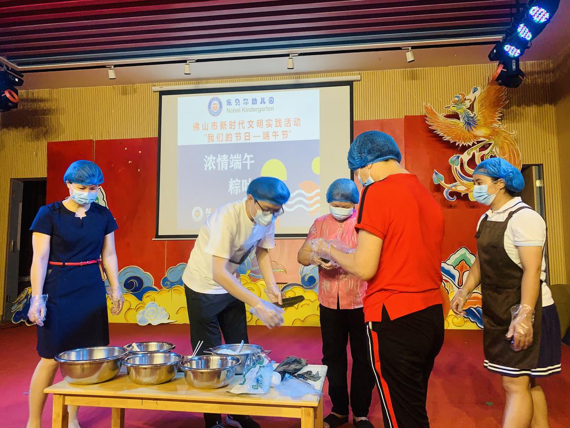 老师与家长一起体验包粽子的乐趣.jpg